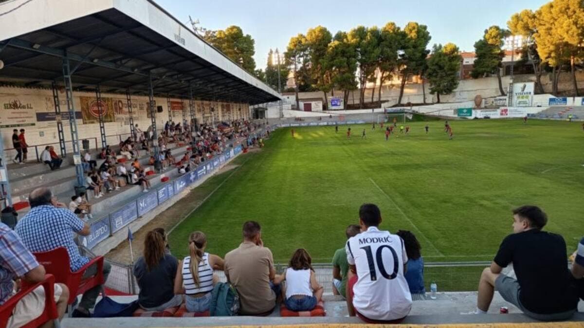 Público siguiendo un partido desde la grada junto al terreno de juego.